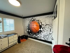 Kids bedroom accent wall with a 3D basketball mural and black painted trim border