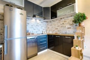 Small kitchen with glossy dark gray cabinets and a whitewashed brick backsplash