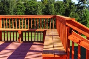 Deck corner with built-in wood benches and railing freshly stained bright cedar orange