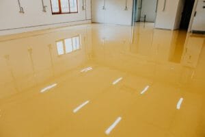 Industrial room with a freshly poured yellow self-leveling epoxy floor and white painted walls