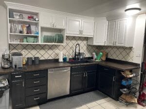Two-tone painted kitchen cabinets with white uppers, black lowers and a diamond tile backsplash